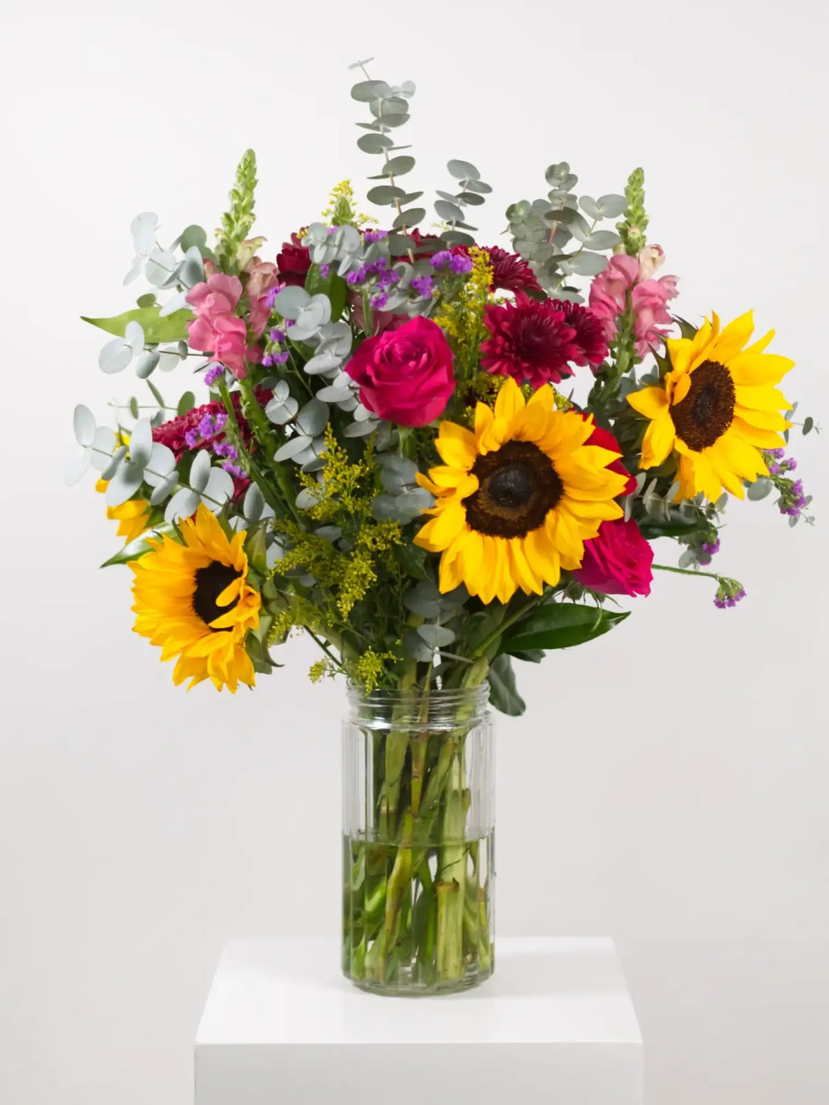 A bright mixed seasonal bouquet of flowers presented in a glass vase or wrapped in kraft paper, suitable for a colleague birthday or Teacher's Day gift.