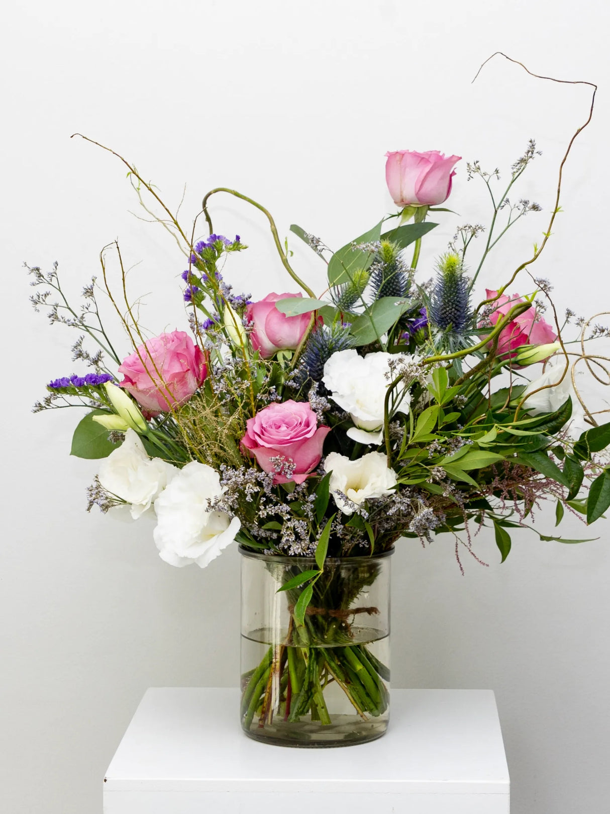 Bouquet of pastel flowers in a clear vase suitable for remembering someone you once loved.