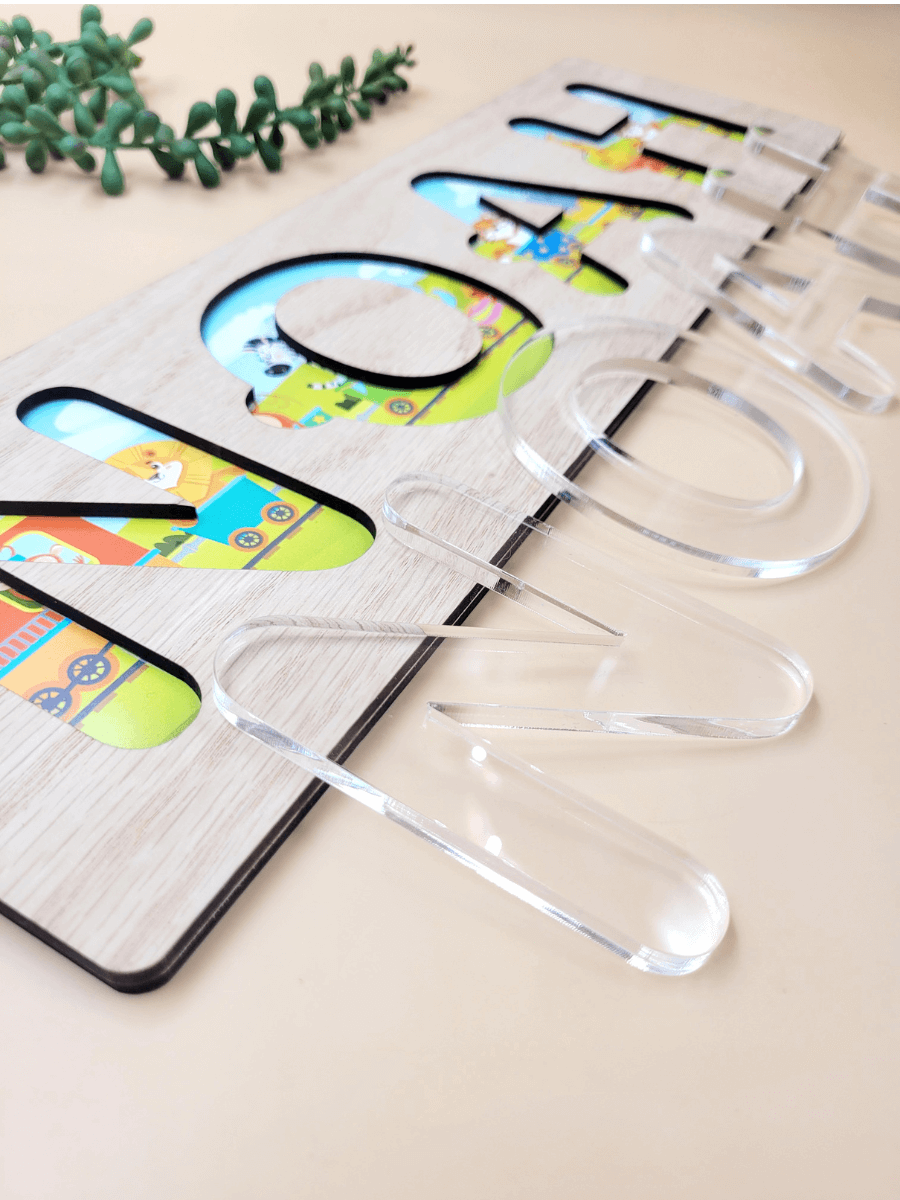 Personalised kids puzzle with clear acrylic letters and colorful printed background on oak veneer wood base