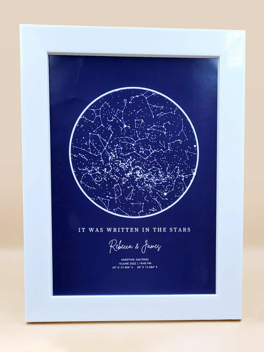 Framed personalised star map print titled 'It Was Written in the Stars' showcasing constellations against a navy background.