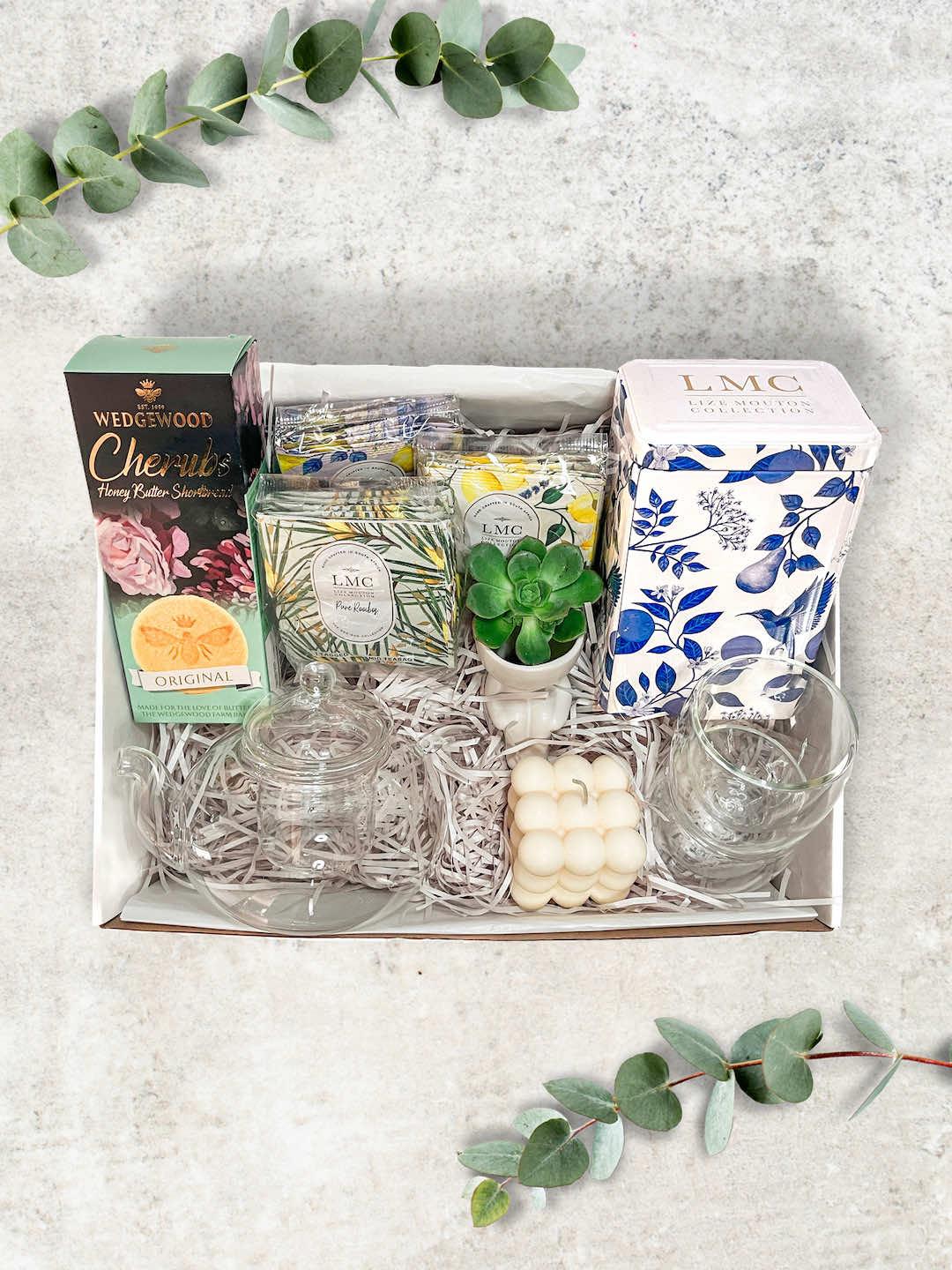 Totally Tea Gift Box featuring a glass teapot, double-walled tea cups, soy wax bubble candle, Wedgewood Honey, and tea selection.