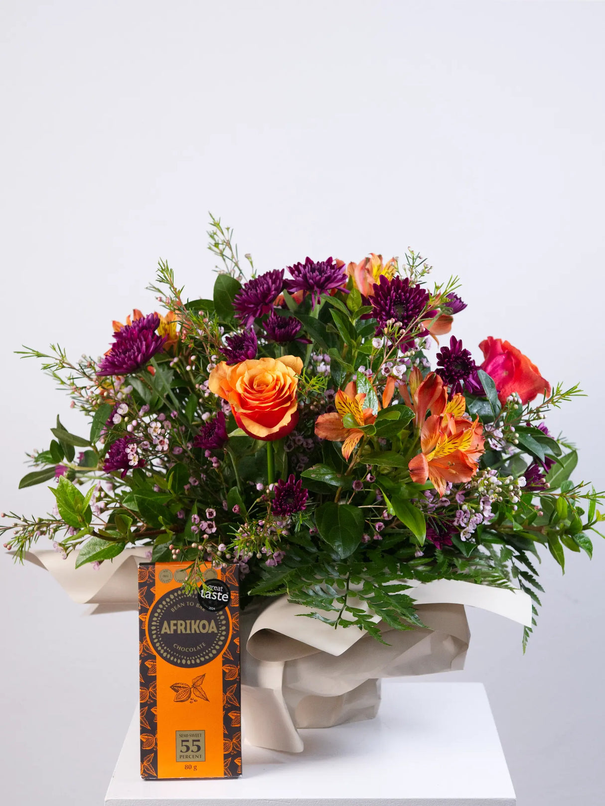 Bouquet of flowers with a box of chocolates on a white background