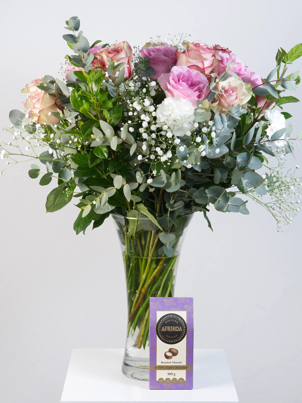 Blush pink rose and white carnation bouquet with eucalyptus in trumpet vase with Afrikoa dark chocolate