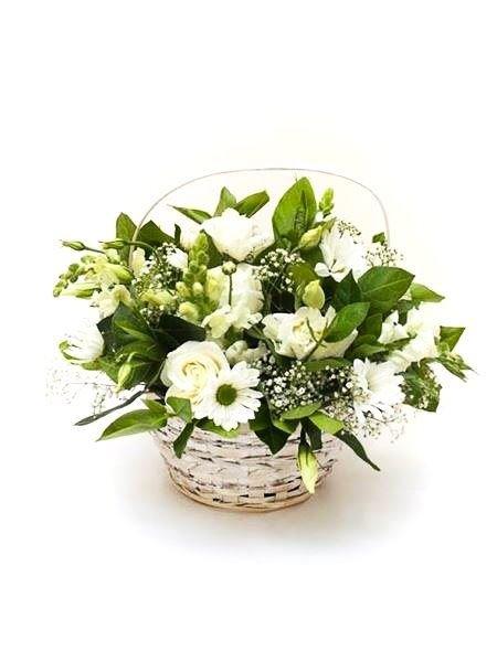 A sympathy basket arrangement consisting of white and green flowers, placed in a round wicker basket.
