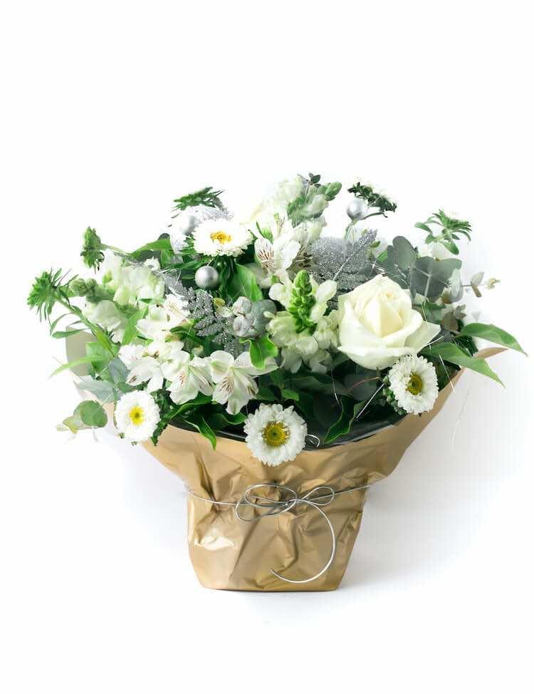 White and greenery-filled floral basket celebrating a summery South African-style Christmas with sparkling silver accents.