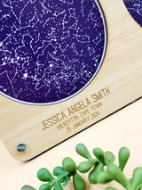 Custom star map with wooden frame displaying constellations and engraved personal details. Ideal for special occasions and gifts.