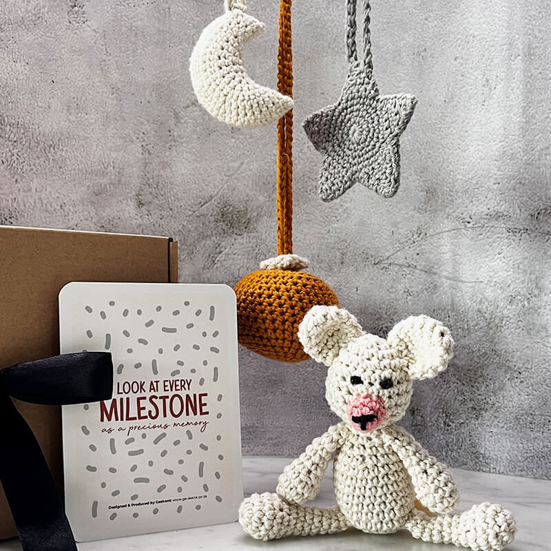 Celestial Snuggles set featuring Joy Republic crochet sun, moon, star mobiles, a teddy bear, and milestone cards for newborns.