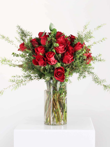 Beautiful classic red rose bouquet in a clear vase, perfect for romantic occasions and Valentine's Day.