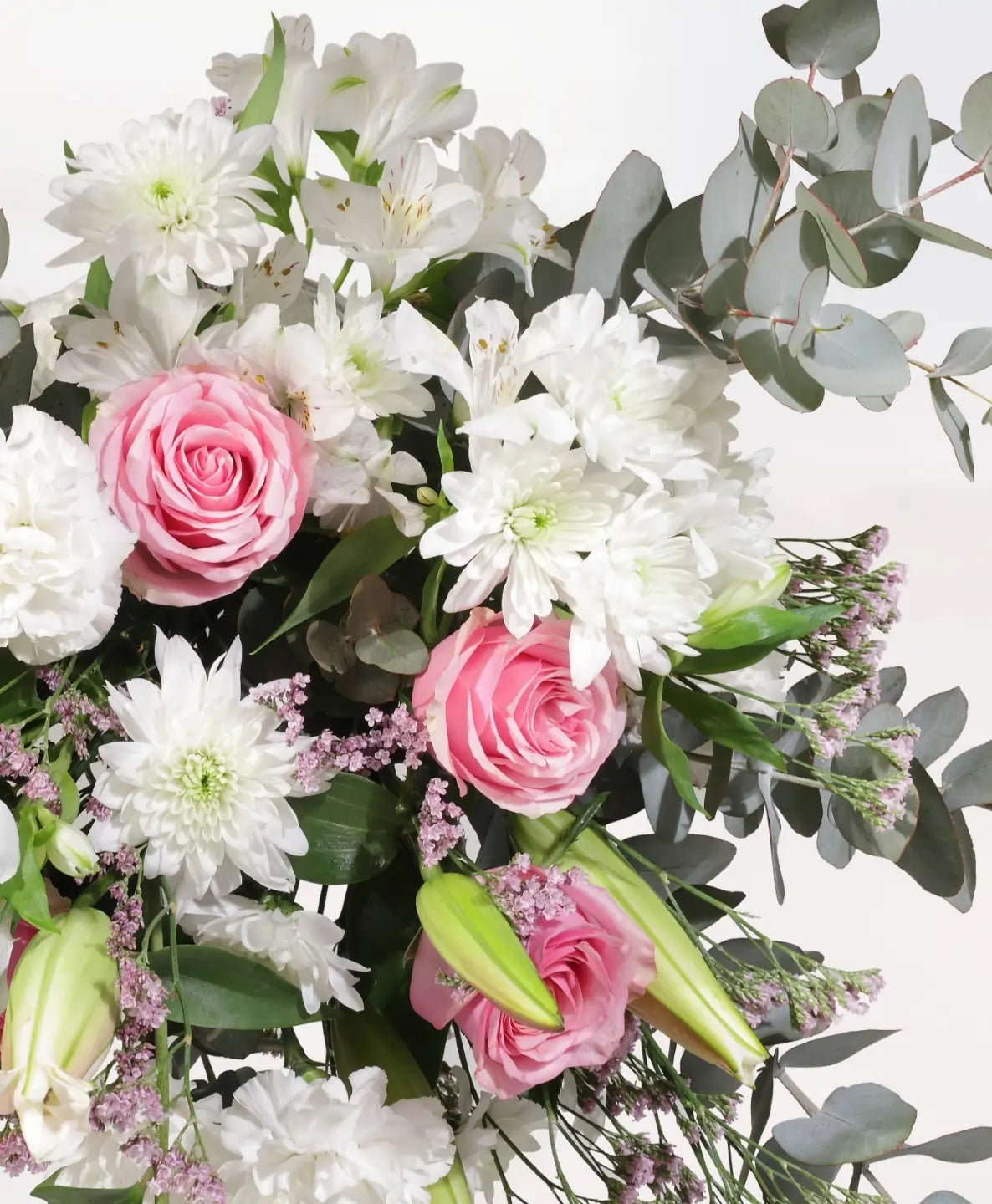 Pink and white luxury flower bouquet close-up with pink roses, white chrysanthemums, white alstroemeria and eucalyptus - soft romantic arrangement detail