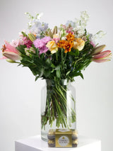 Vase filled with colorful flowers and a box of Ferrero Rocher chocolates, perfect for sending joy.