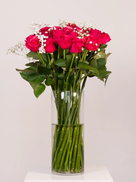 Bouquet of dark pink roses in a clear vase perfect for self celebration for smashing your goals or celebrating someone else's achievements.