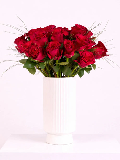 Bouquet of red roses in a white vase on a white background