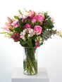 Deep, long-term passion captured in a single arrangement with pink and lilac roses, seasonal flowers and greenery. Presented in a glass vase or kraft paper tied with twine.