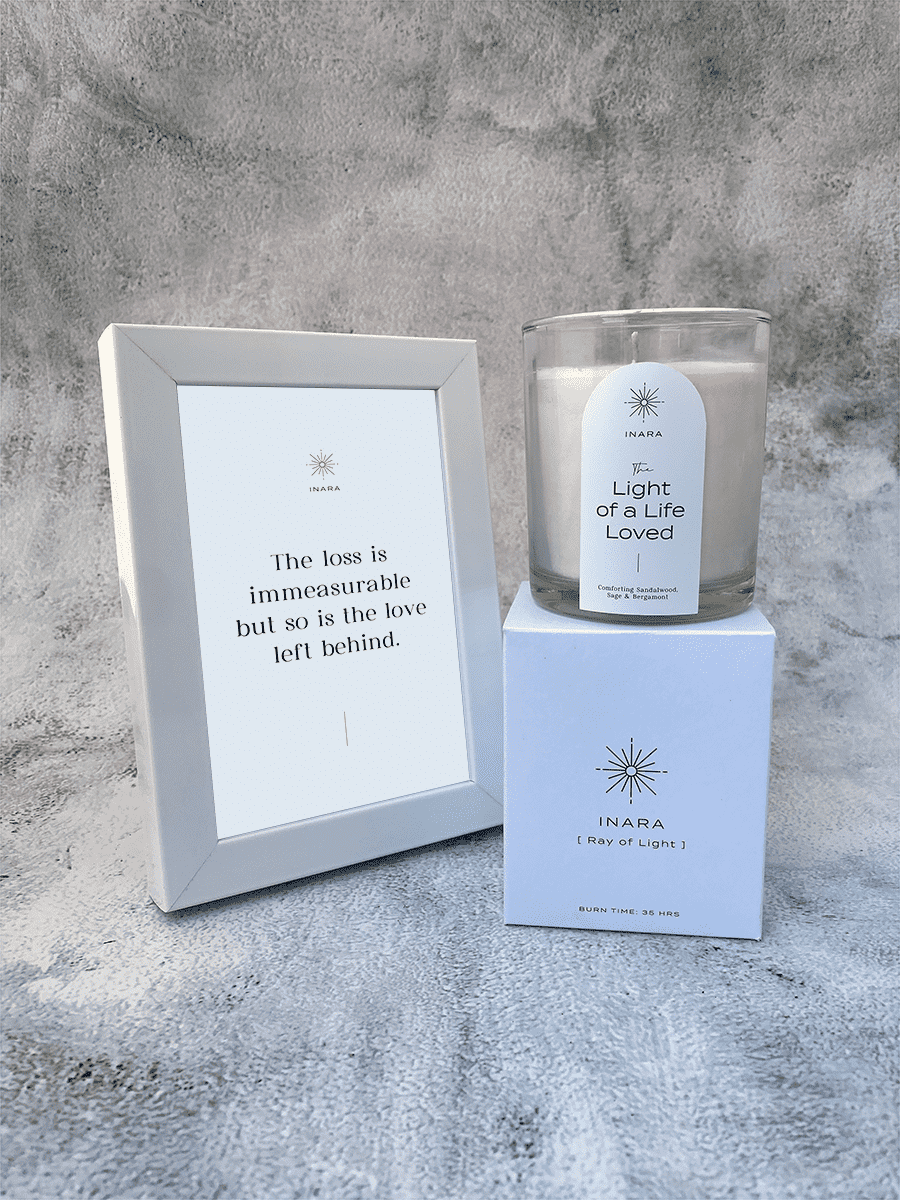 Inara Bereavement Candle and framed quote, "The loss is immeasurable, but so is the love left behind," on a textured background.