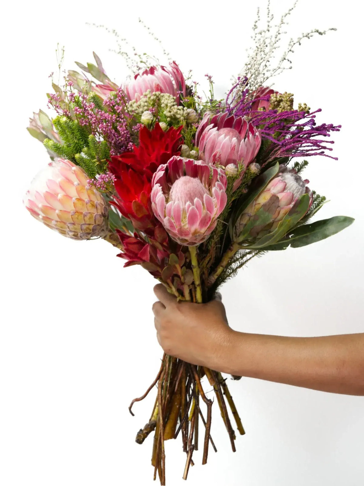 Bloomable's Girl You Is Fynbos bouquet presented in close-up detail. Features stunning pink king proteas, cream blushing bride proteas, vibrant red leucadendrons, delicate pink filler flowers, and lush greenery. This luxurious collection of South African fynbos creates a perfect gift for Valentine's Day, wedding anniversaries or romantic gestures with same-day delivery across South Africa.