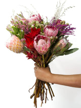 Bloomable's Girl You Is Fynbos bouquet presented in close-up detail. Features stunning pink king proteas, cream blushing bride proteas, vibrant red leucadendrons, delicate pink filler flowers, and lush greenery. This luxurious collection of South African fynbos creates a perfect gift for Valentine's Day, wedding anniversaries or romantic gestures with same-day delivery across South Africa.