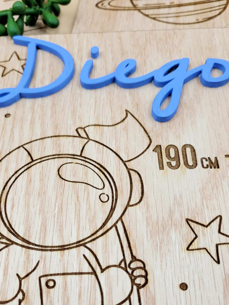 Personalised kids growth chart with engraving, blue acrylic name "Diego," astronaut and star design, made from veneer wood.