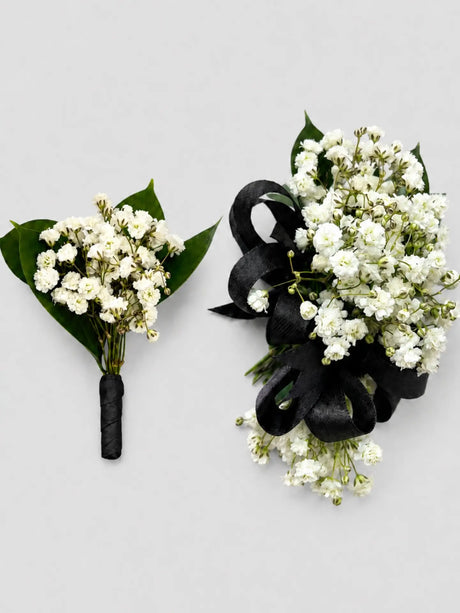 Two floral arrangements with white flowers and black ribbons on a light gray background