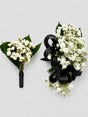 Two floral arrangements with white flowers and black ribbons on a light gray background