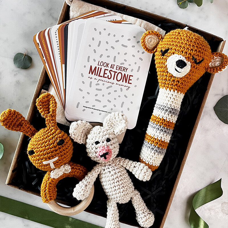 Hugs & Milestones Magic box with Joy Republic crochet rattler, teddy bear, teether, and milestone cards for baby celebrations.