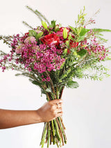 Bouquet of pink roses and penny gum with lush greenery, hand-held, showcasing a vibrant mix of blush hues perfect for any occasion.
