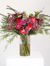 Vibrant pink flower bouquet with roses, penny gum, and greenery arranged elegantly in a vase, ideal for any occasion.