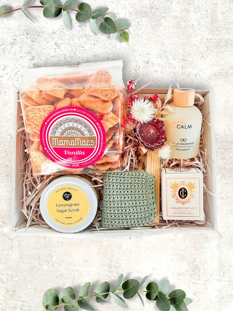 Luxury pamper gift box with vanilla snacks, lemongrass scrub, body lotion, and crochet cloth, perfect for relaxation and self-care.