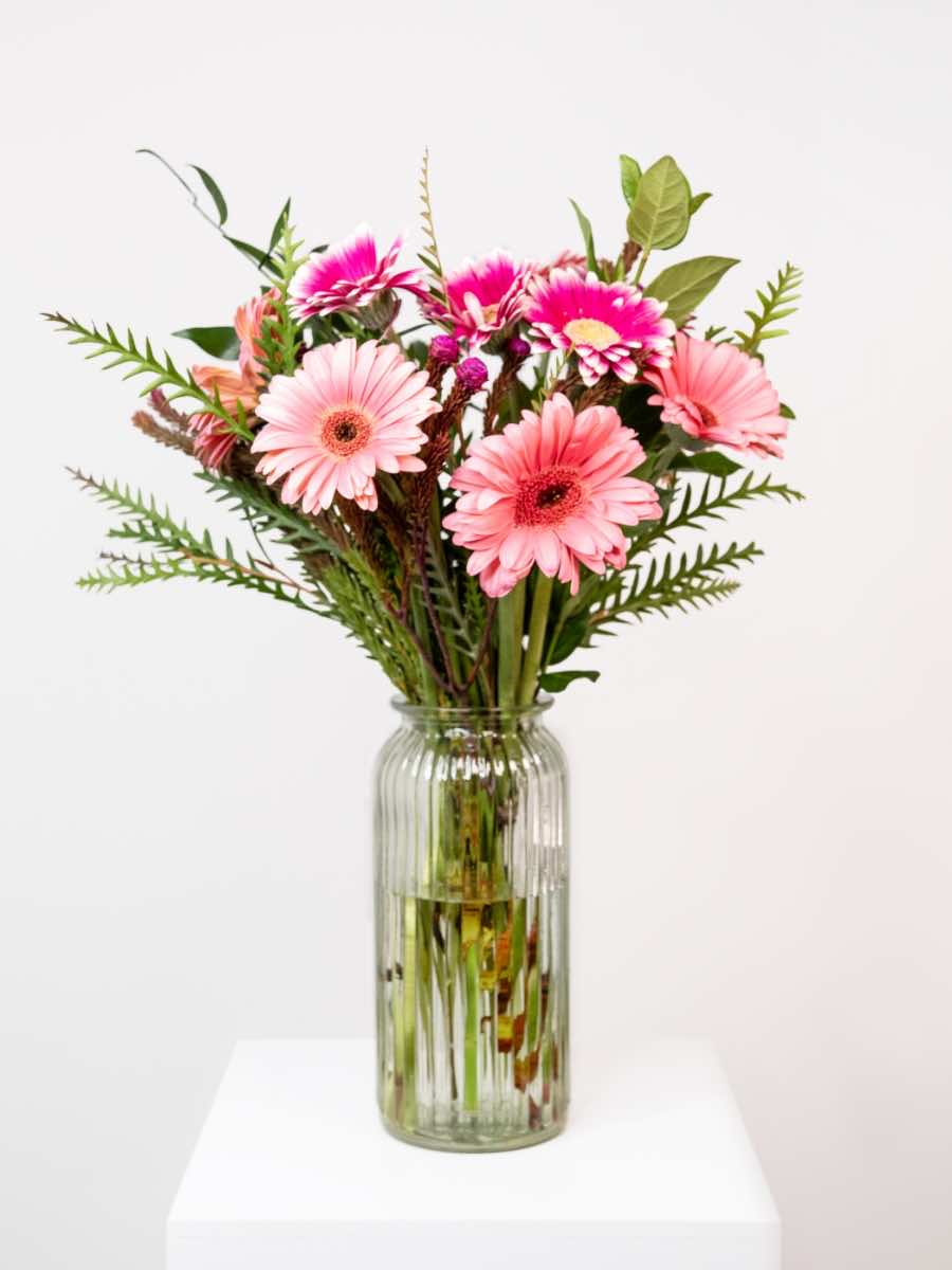 Mixed Gerbera Bunch featuring pink daisies and greenery in a vase, symbolizing love, joyfulness, and admiration.