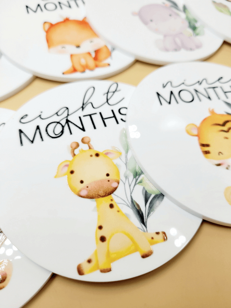 Close up of monthly discs with baby animal illustrations in the Personalised Baby Milestone Disc Set 