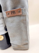 Personalised canvas leather wine carrier with initials PB, featuring a bottle and elegant craftsmanship.