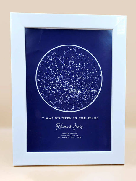 Framed personalised star map print titled 'It Was Written in the Stars' showcasing constellations against a navy background.