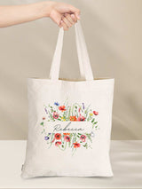 Holding a personalized cotton tote bag with floral design and "Rebecca" text, eco-friendly gift, sustainability, vibrant print.