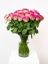 Elegant bouquet of pink roses in a glass vase, perfect for expressing love and admiration with a vintage touch.