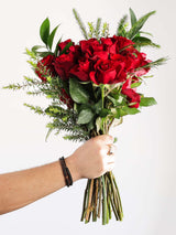Hand holding a classic red rose bouquet, perfect for romantic occasions and gift deliveries.