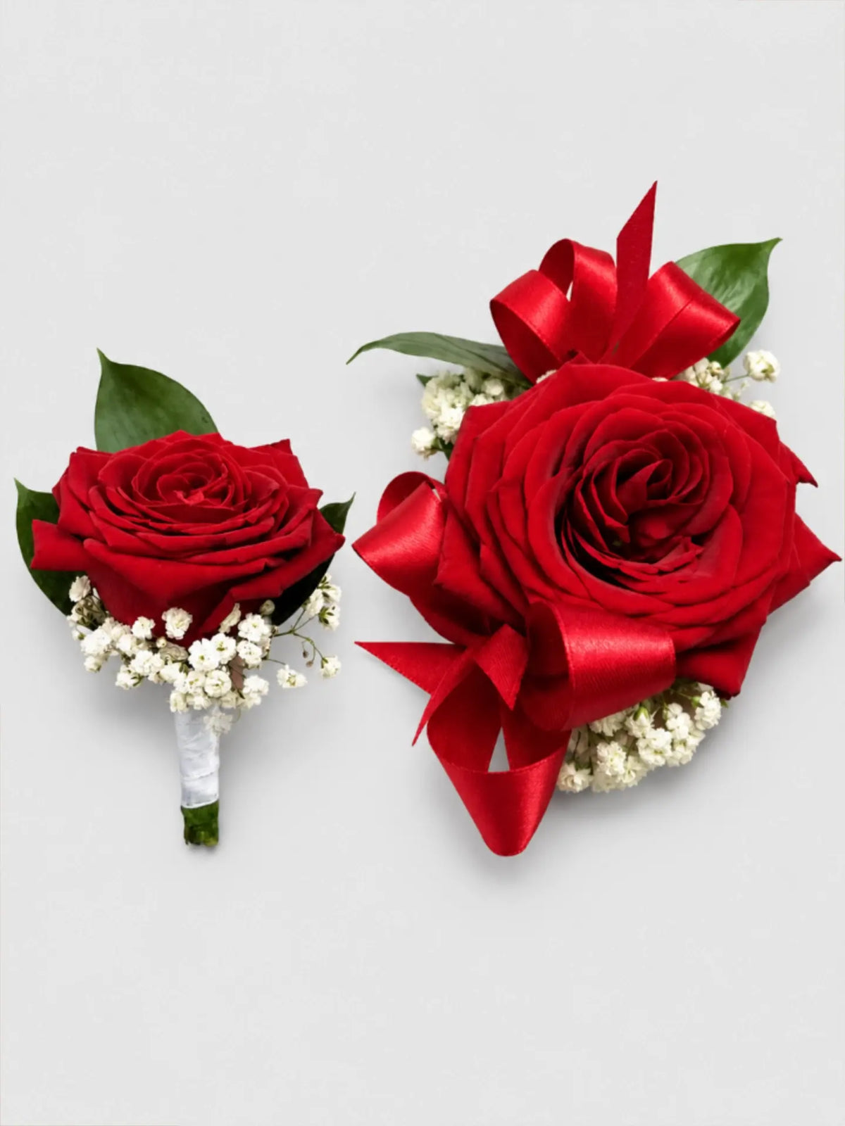 Two red rose bouquets with ribbons on a light gray background