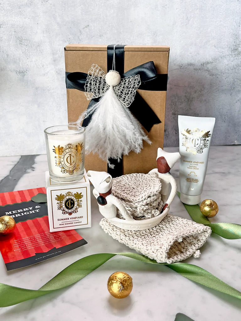 Gift set with candle, soap, and other items on a textured surface