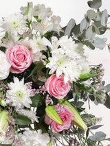 Pink and white luxury flower bouquet close-up with pink chrysanthemums, white roses, white carnations, pink alstroemeria and white lilies - elegant mixed arrangement detail