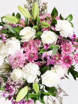 Soft pink and white flower arrangement detail featuring pink roses, white chrysanthemums, white alstroemeria and eucalyptus - romantic elegant bouquet close-up