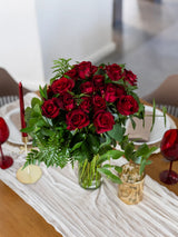 Bouquet of red roses on a dining table with white tablecloth
