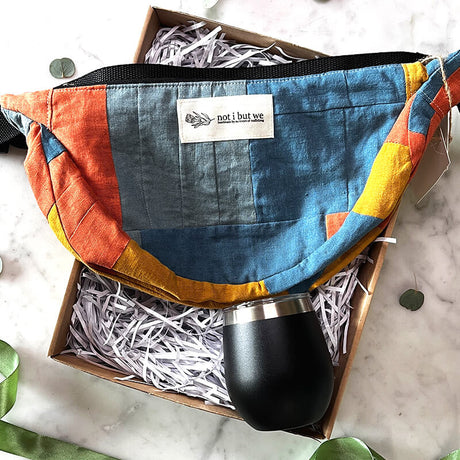 Together in Style product box featuring Not I But We Patchwork Moon Bag and black Lizzard Thermal Cup on a marble background.