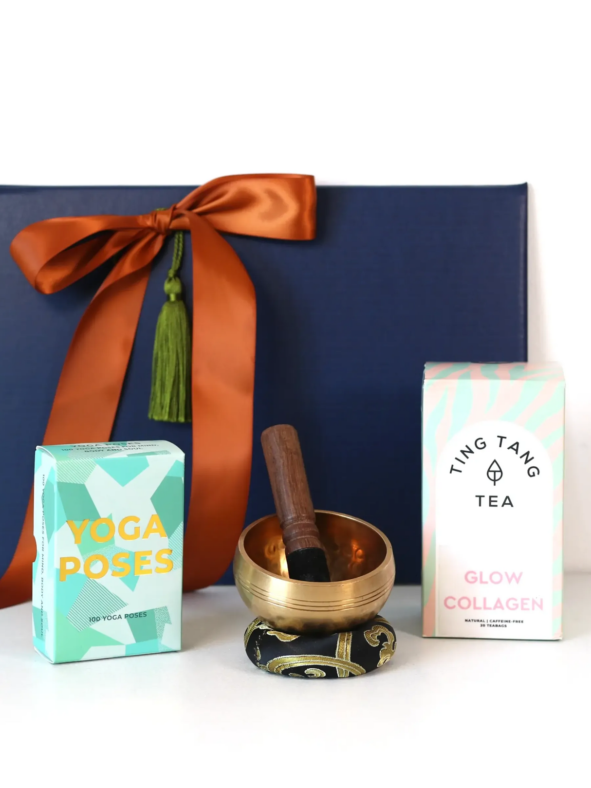 Yoga Serene Calm & Flow Gift Set contents, featuring yoga cards, a Tibetan singing bowl, and Ting Tang glow collagen tea.