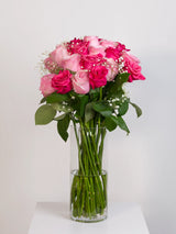 Light pink and hot pink rose bouquet with baby's breath in glass vase