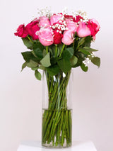 Light pink and hot pink rose bouquet with baby's breath in glass vase