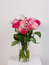 Light pink and hot pink rose bouquet with baby's breath in glass vase