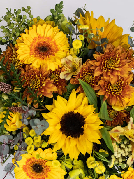Close-up of Bloomable's Happy Bouquet featuring bright yellow sunflowers, golden-orange chrysanthemums, yellow gerbera daisies, delicate alstroemeria, and eucalyptus accents. A cheerful arrangement of sunshine-coloured flowers available with same-day delivery across South Africa.