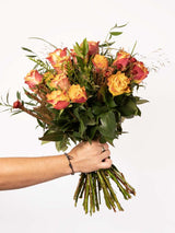 Vibrant orange rose bouquet with greenery, designed by local South African florists, showcasing seasonal flowers and small business support.