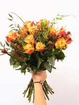 Vibrant orange rose bouquet with greenery, hand-tied by local South African florists, showcasing seasonal floral beauty and craftsmanship.