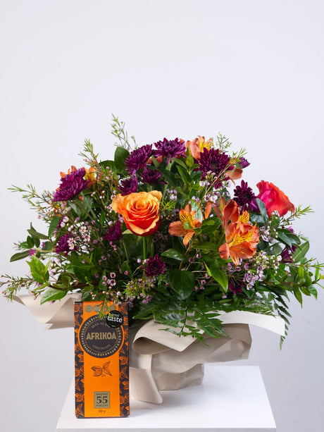 Bouquet of flowers with a box of chocolates on a white background