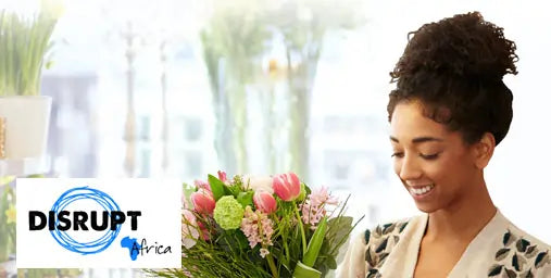 Woman holding a bouquet of flowers with 'Disrupt Africa' logo in the corner