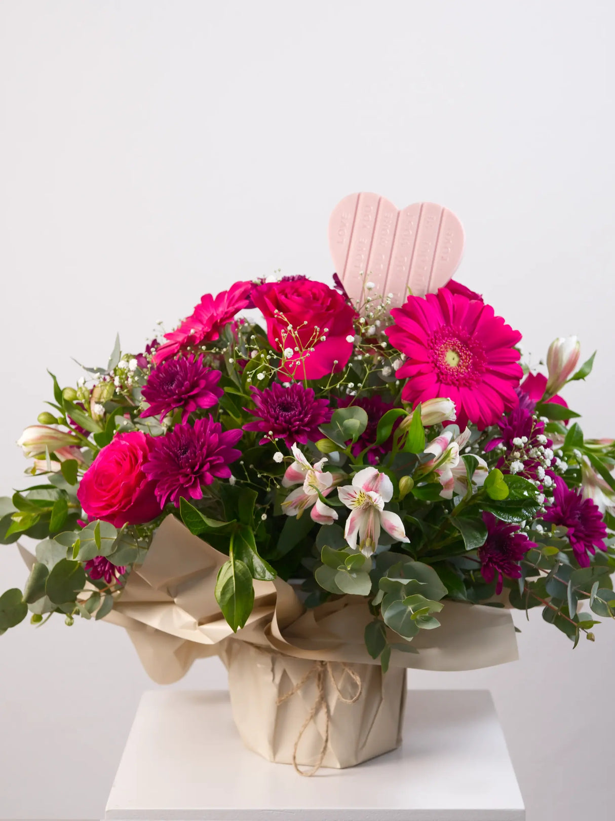 Pink mixed flower posy with gerbera, roses and chrysanthemums with heart-shaped chocolate 
